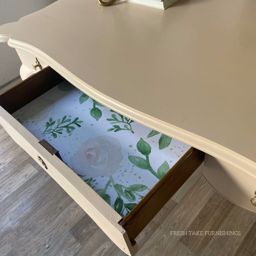 Inside the drawer of the writing desk with floral wallpaper