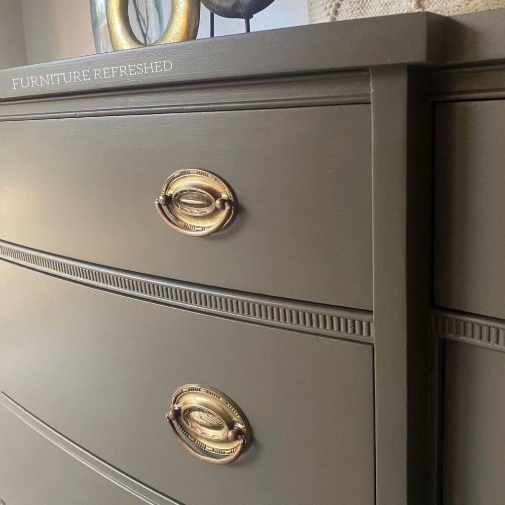 Elegant gray dresser with vintage brass handles, perfect for modern bedroom decor.