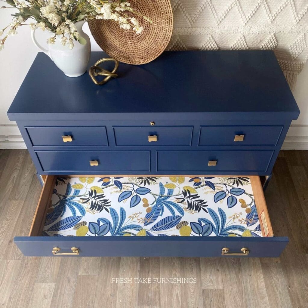 After photo of painted cedar chest with bottom drawer open with the drawer lined in a floral wallpaper