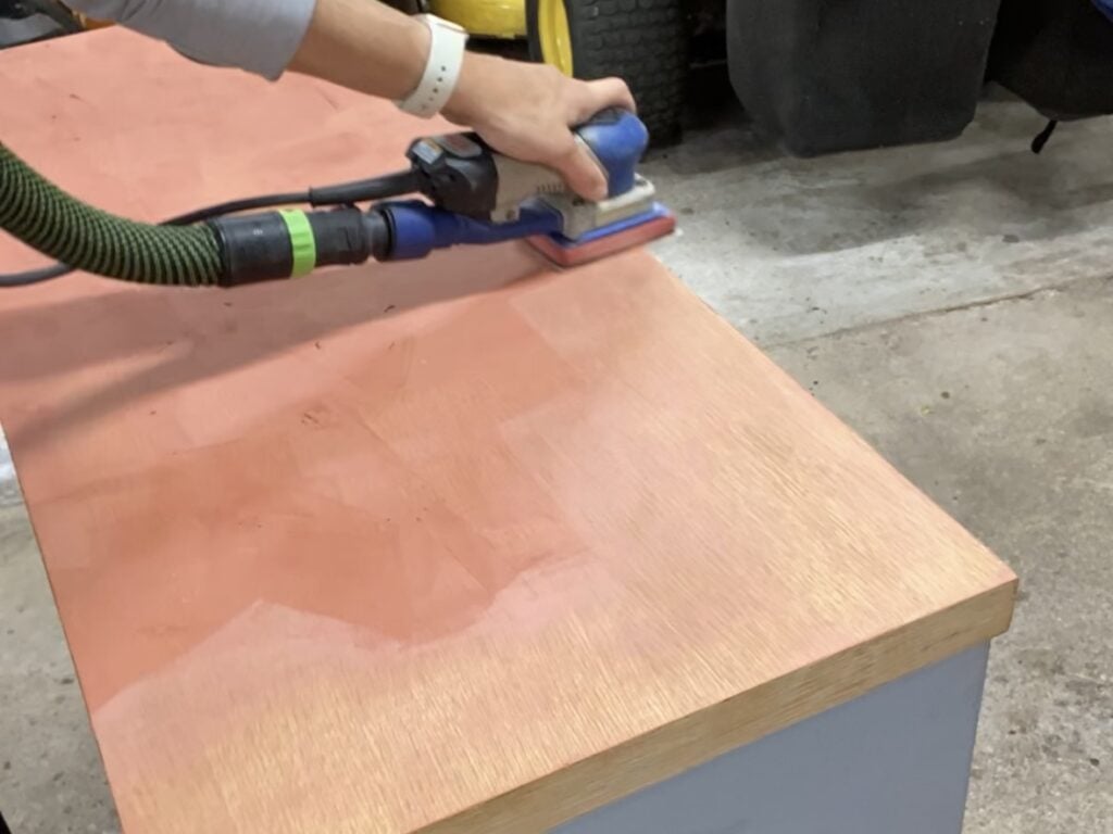 Sanding of Bondo glazing and spot putty after using it to fill scratches in the top of a dresser.