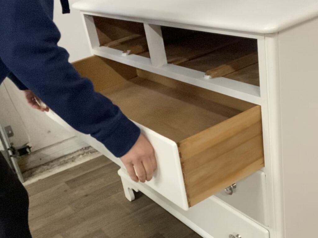 Sliding a drawer in and out after using a drawer lubricant.