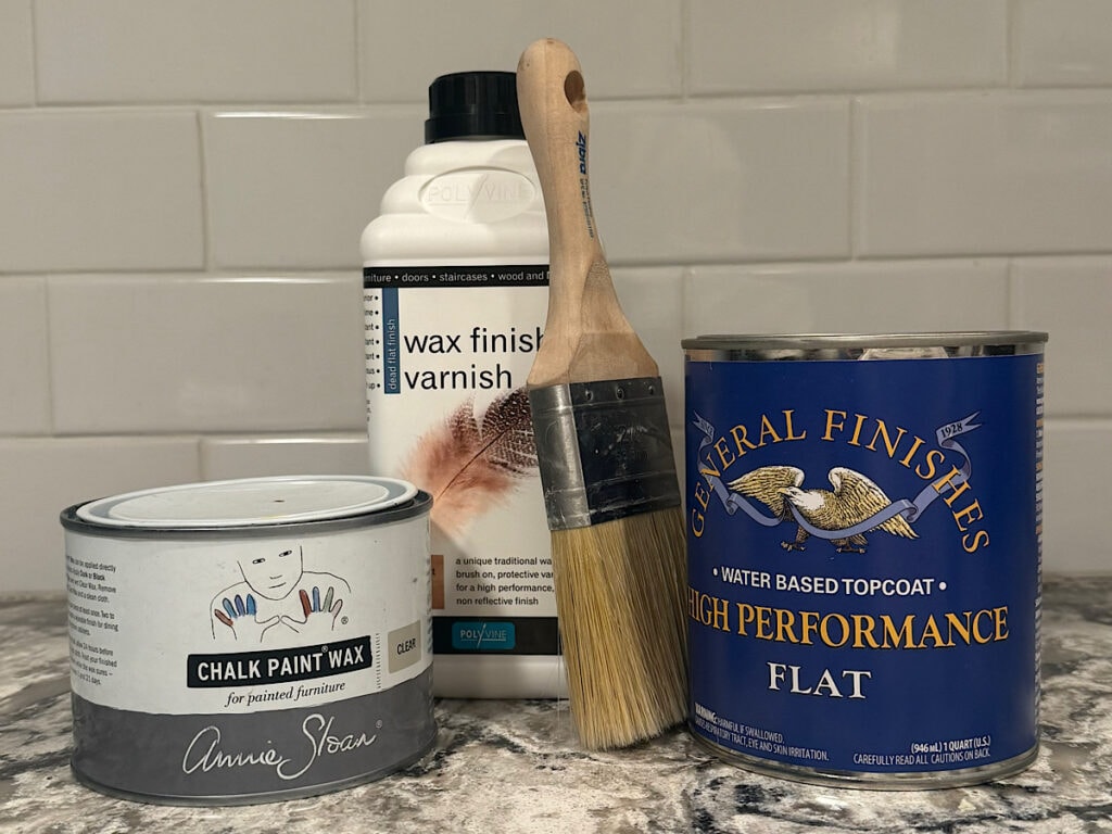 Photo of my favortire products to seal painted furntiure. Pictured is Annie Sloan Clear Wax, Polyvine Wax Finish Varnish, General Finishes High Performance Waterbased Topcoat and the Zibra topcoat brush.