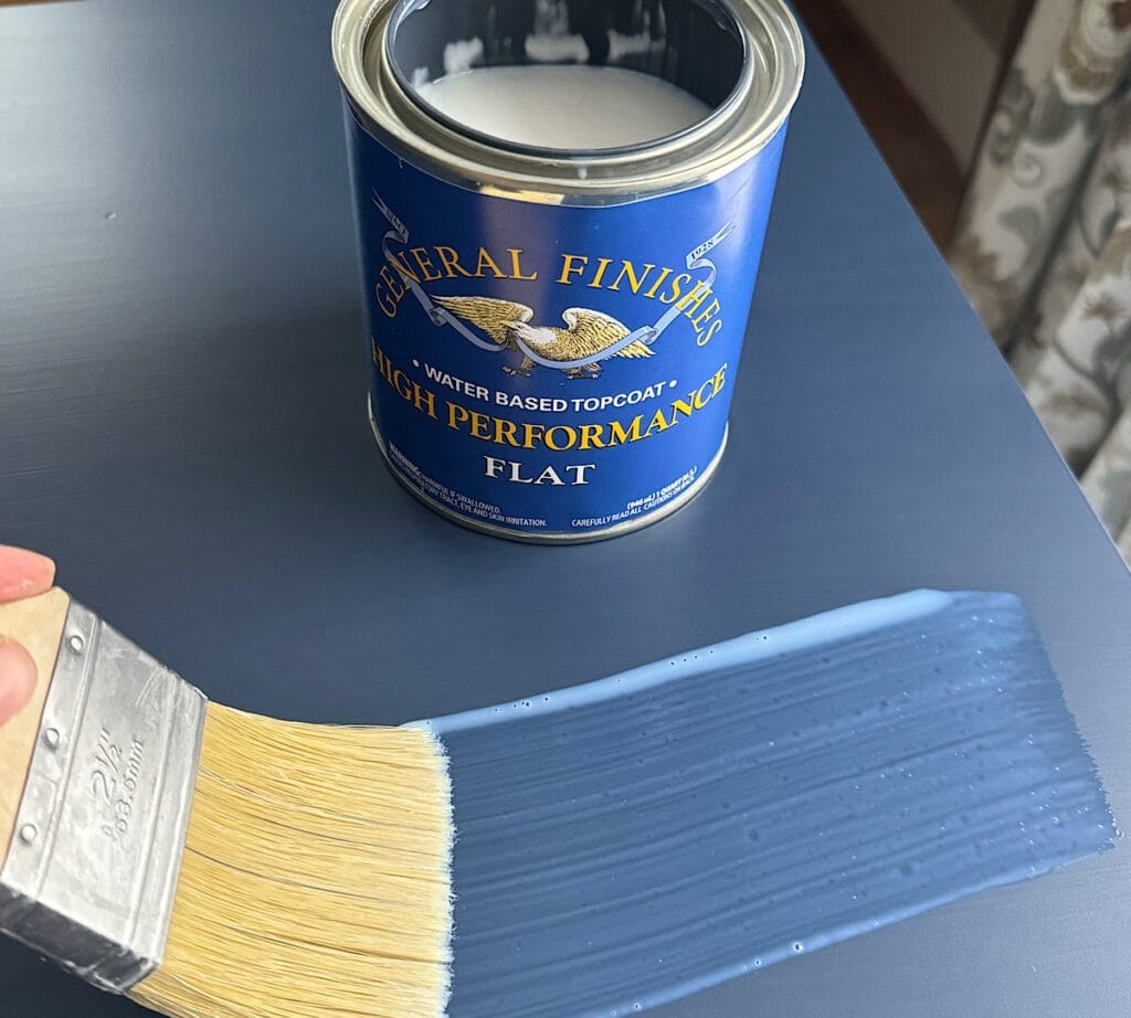 Image of a person brushing on a coat of General Finishes High Performance Topcoat with a Zibra topcoat brush.