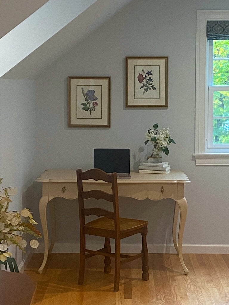 Photo of a desk in a peach color against a light blue wall with light wood floors,
