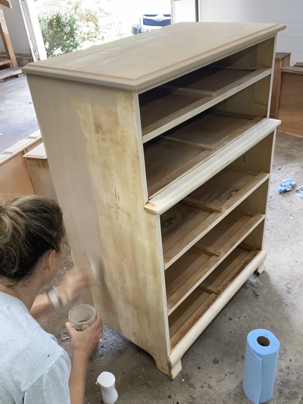 Applying the paint wash to the side of the dresser.