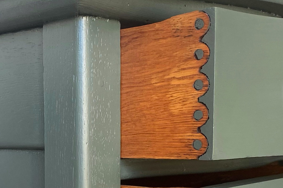 Close up photo of a knapp joint that on a painted green furniture piece