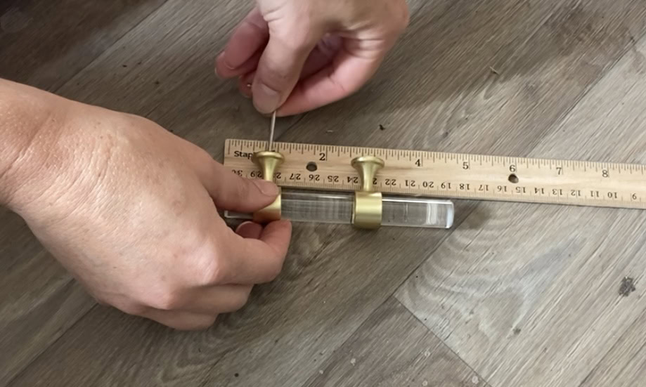 Adjustable hardware being set to the proper size next to a ruler.