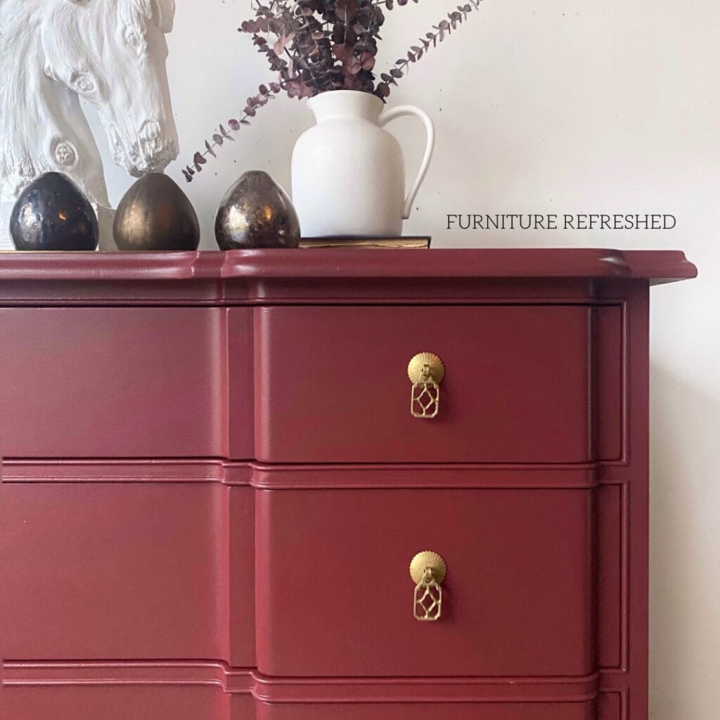 Close of up drawer hardware on a dresser. Hardware is Chinese inspired and made of brass, dresser is red.
