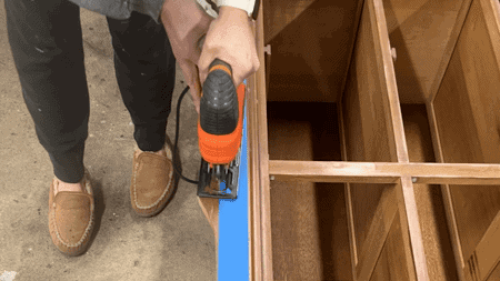 Using a jigsaw to alter the base of a table.