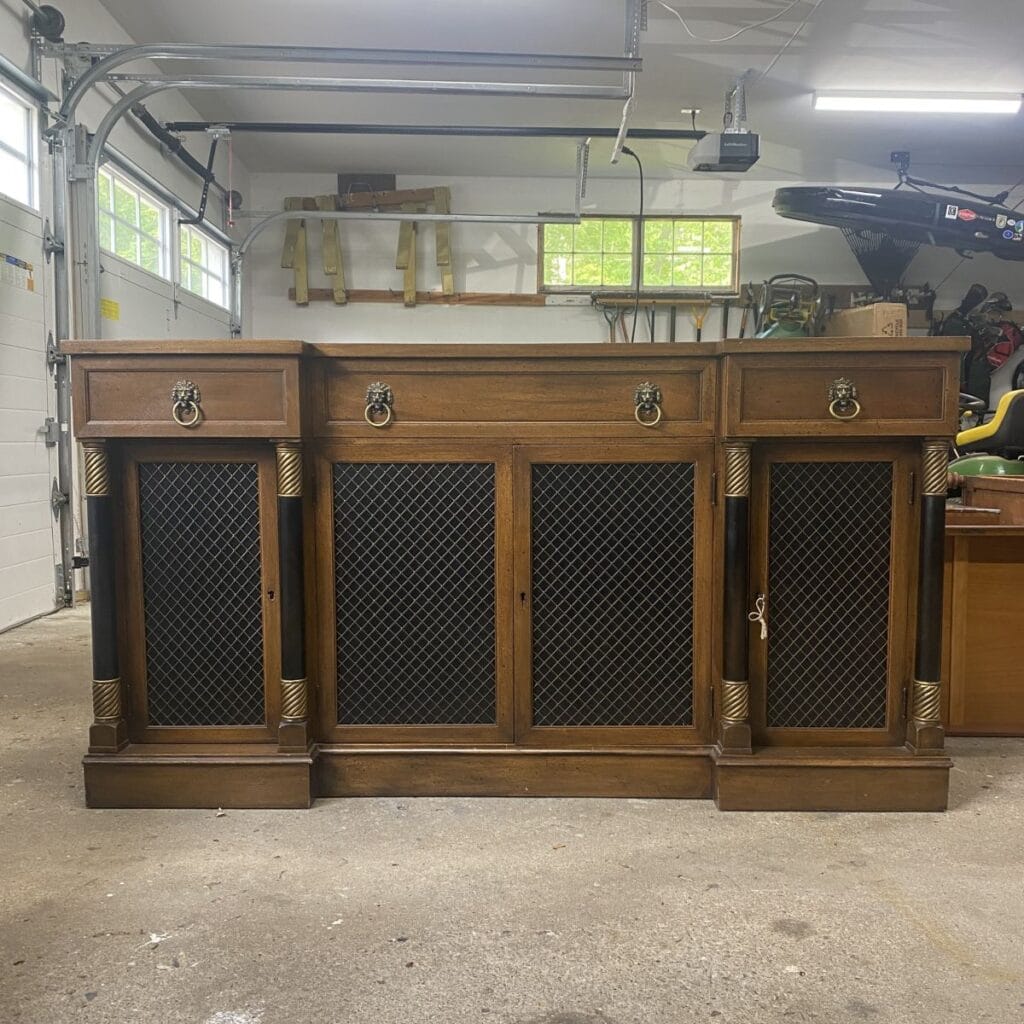 Photo of stained wood buffet with black doors and metal accents before being refinished.