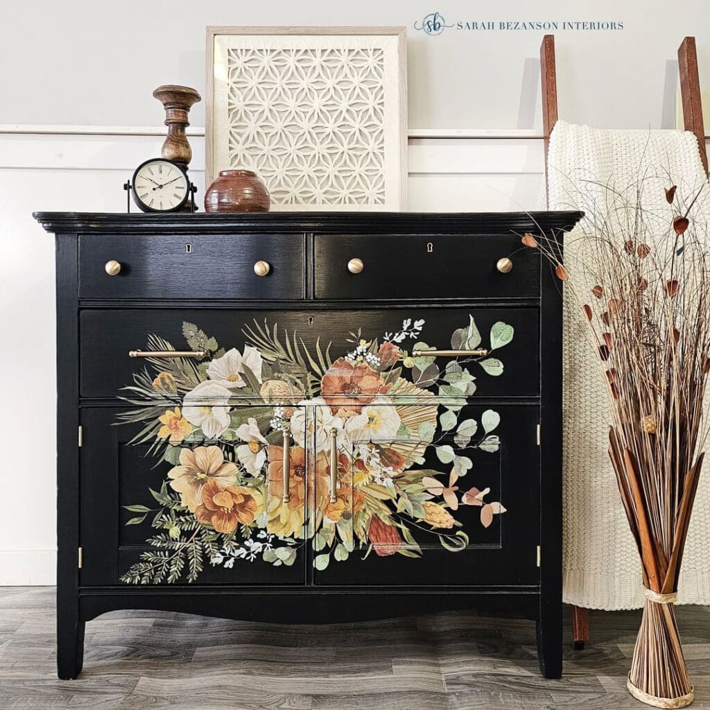 Photo of a black painted washstand with a fall foliage floral design transfer on the front.