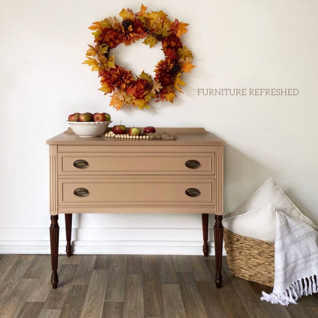 Painted 2 drawer sideboard with a tan paint and dark walnut stained legs. Antique bronzed hepplewhite hardware.