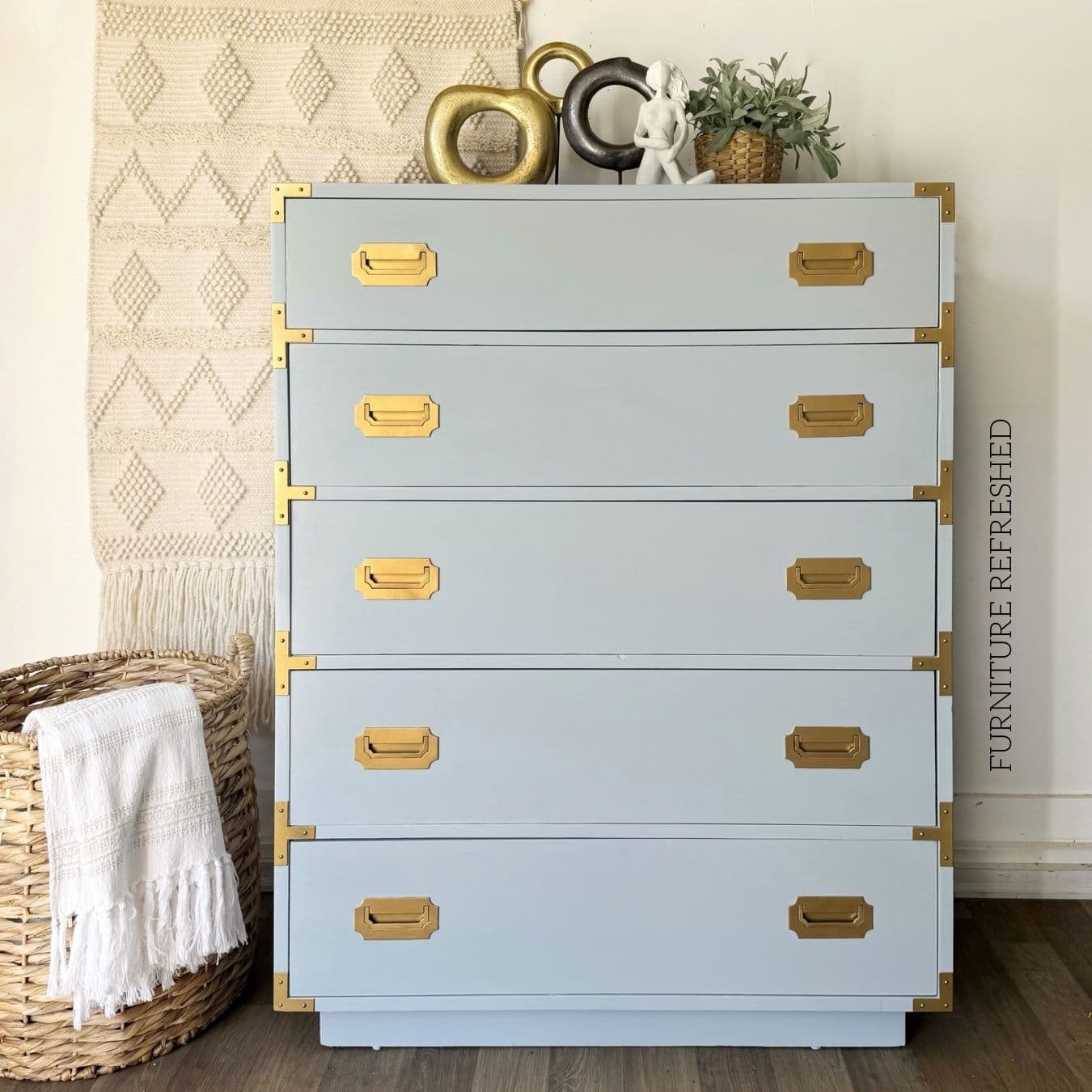 After photo of the 5 drawer dresser used in this makeover. Front view. It is a Dixie Furniture Campaigner style, painted light blue with gold hardware.