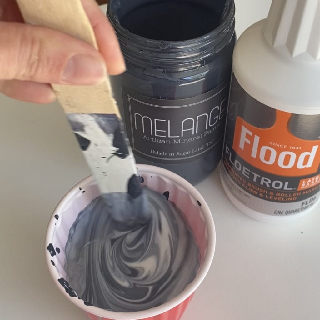 Stirring together paint and Floetrol to make a paint glaze.