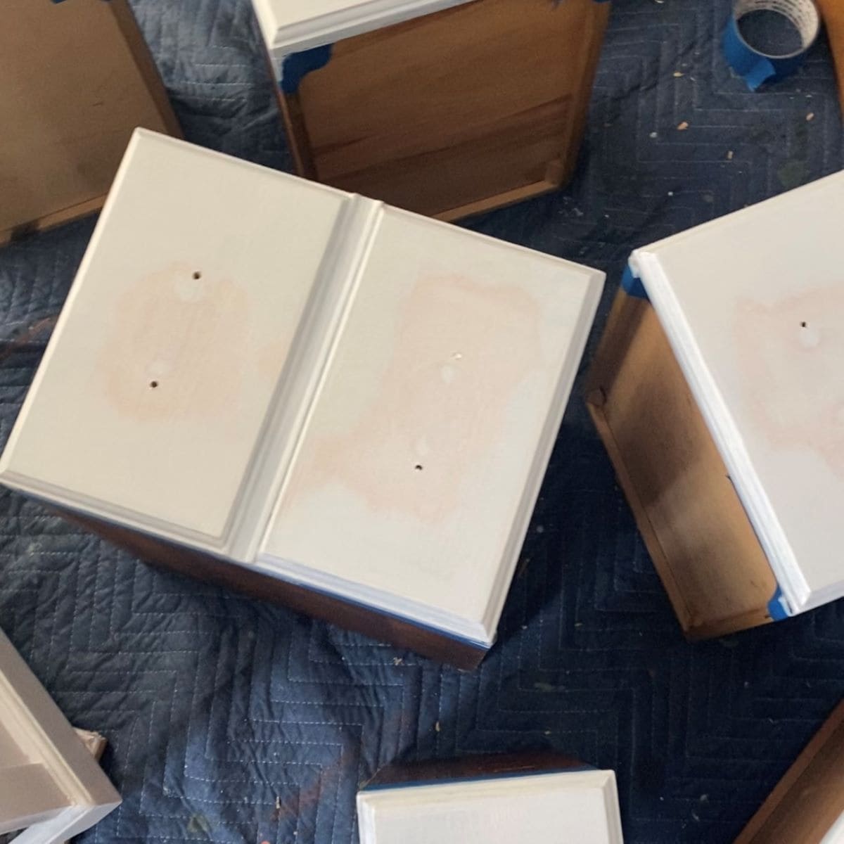 Drawers after two coats of stain blocking primer, some pink bleedthrough is still visible.