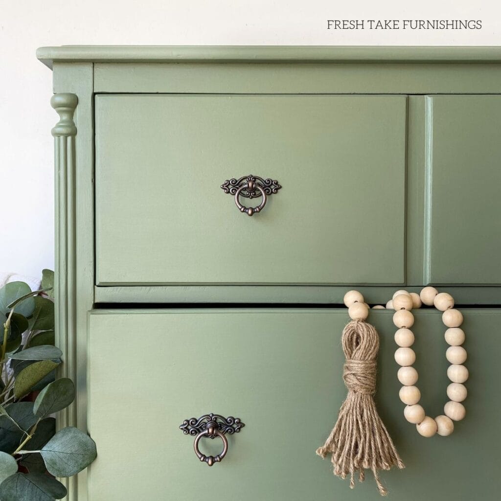 Close up of a hand painted green dresser drawer with a smooth finish.