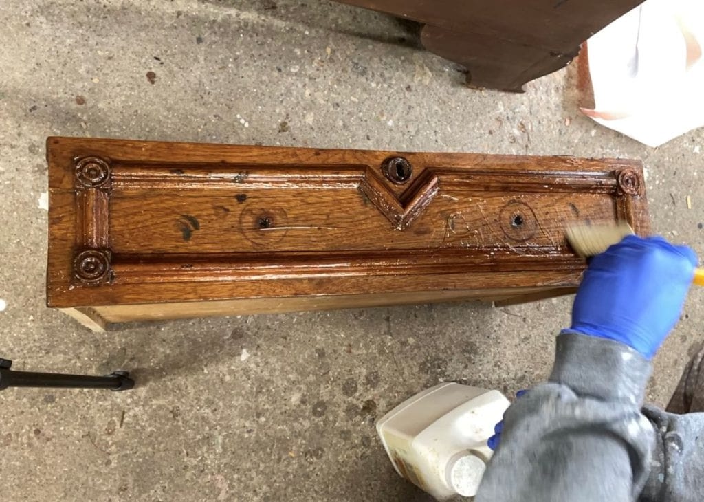 Stripping the finish off of a furniture drawer.