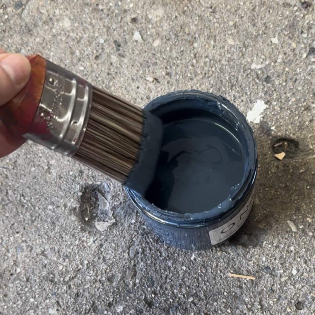 Dipping my paintbrush into navy furniture paint.