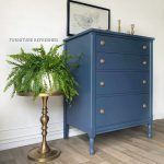 After photo of 4 drawer dresser painted navy blue and updated vintage brass hardware added. photo shows dresser slightly angled.