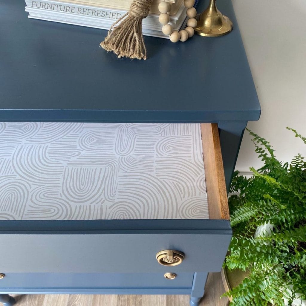 Close up of opened top dresser drawer with a wallpaper drawer liner