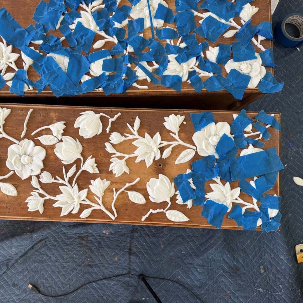 Using painters tape to secure the appliques while they dry.