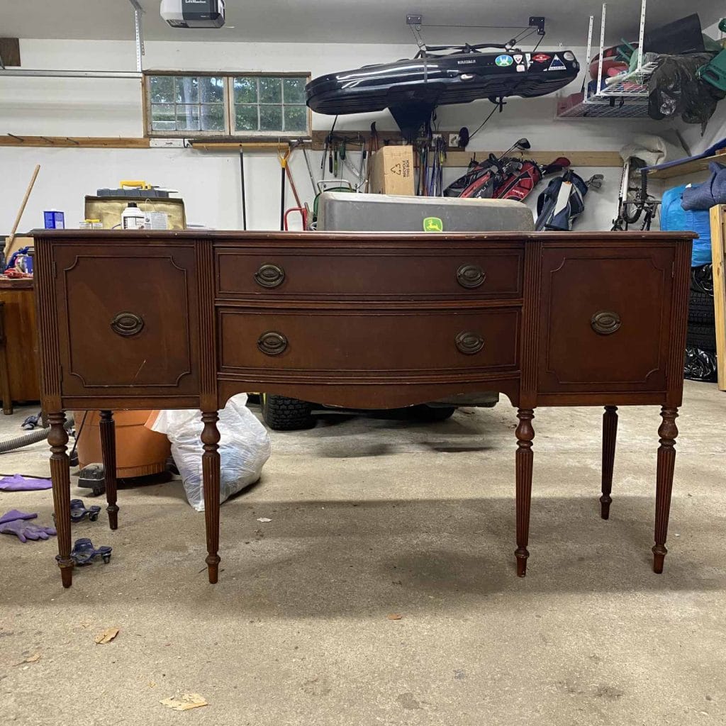 Before photo of a mahogany sideboard with long legs.