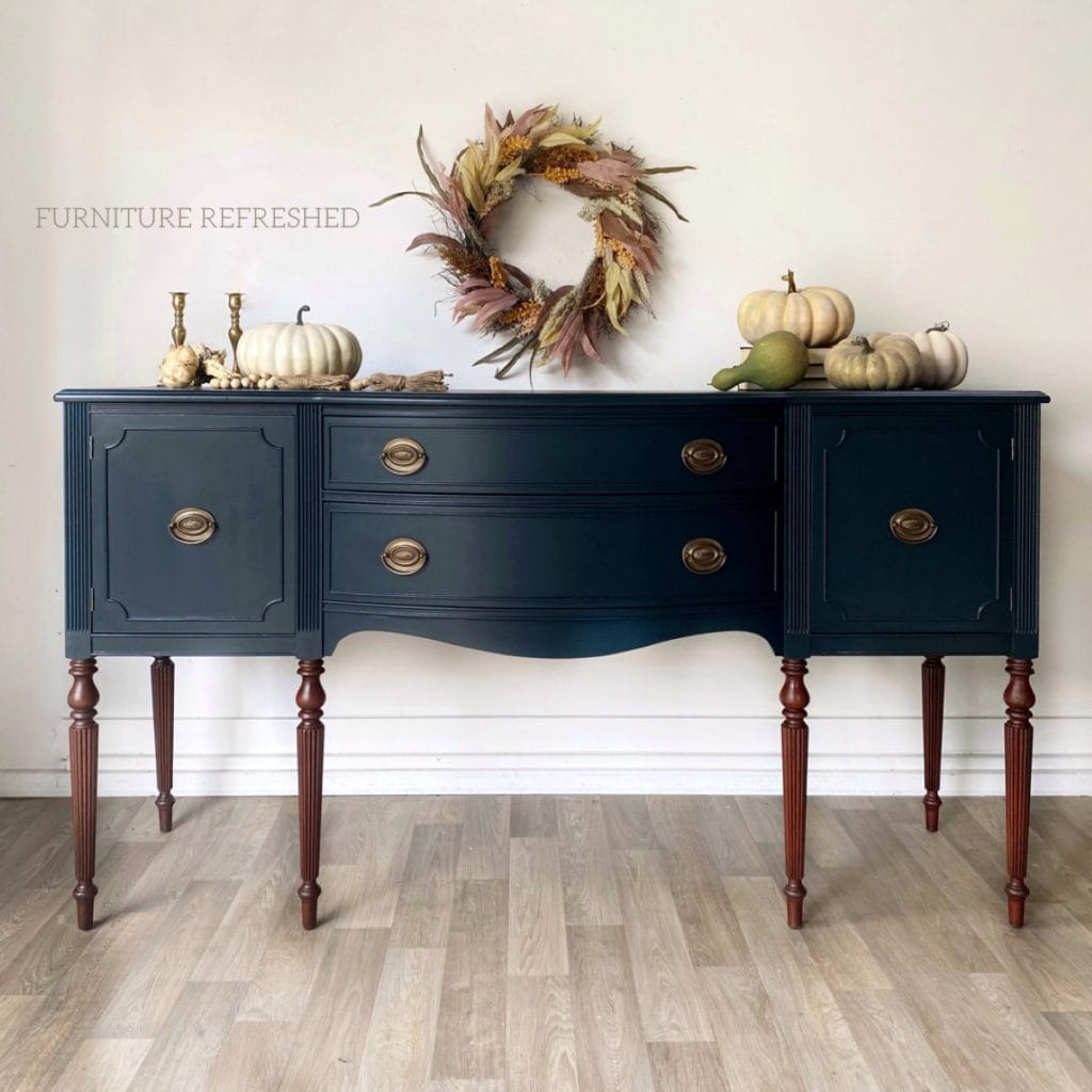 After photo of a sideboard with long legs. Top is painted in a dark teal and legs are stained wood.