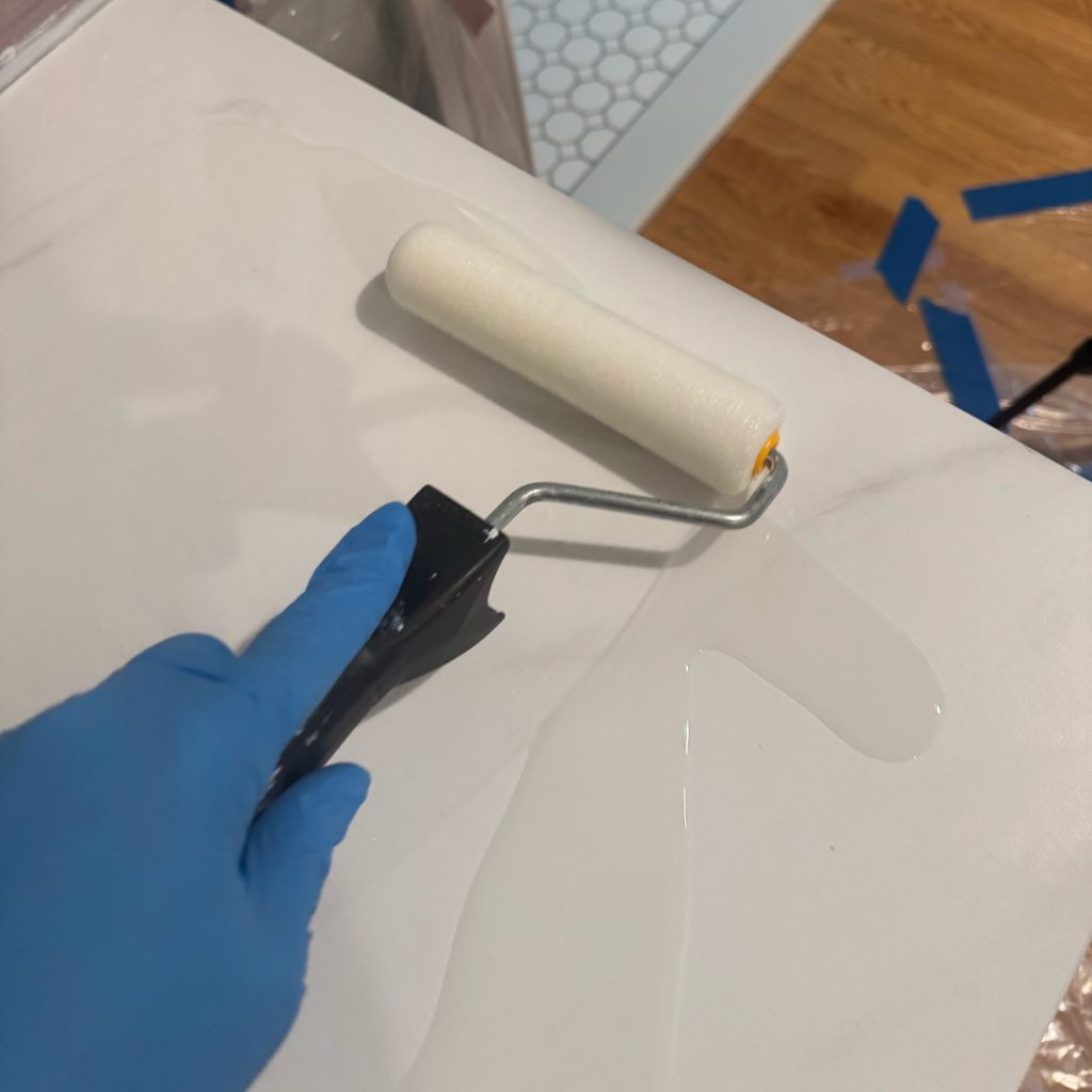 Using a foam roller to distribute the epoxy evenly over the countertop.