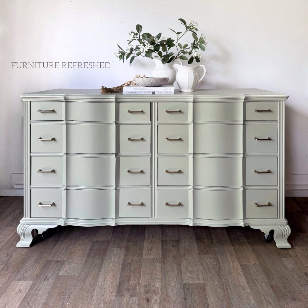 After photo of dresser used in this makeover, painted in a light green with champagne gold bar pulls for hardware