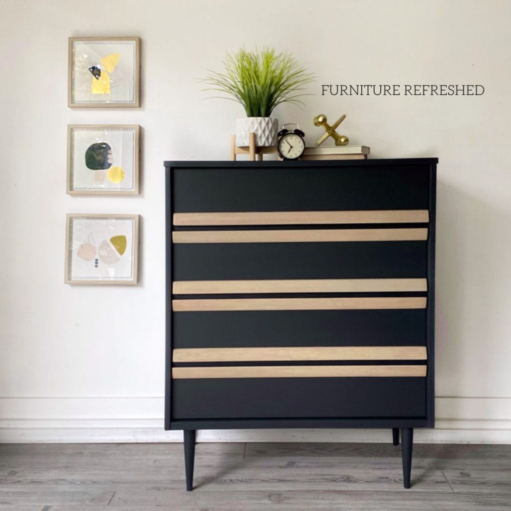 After of MCM tallboy dresser painted black with raw wood handles.