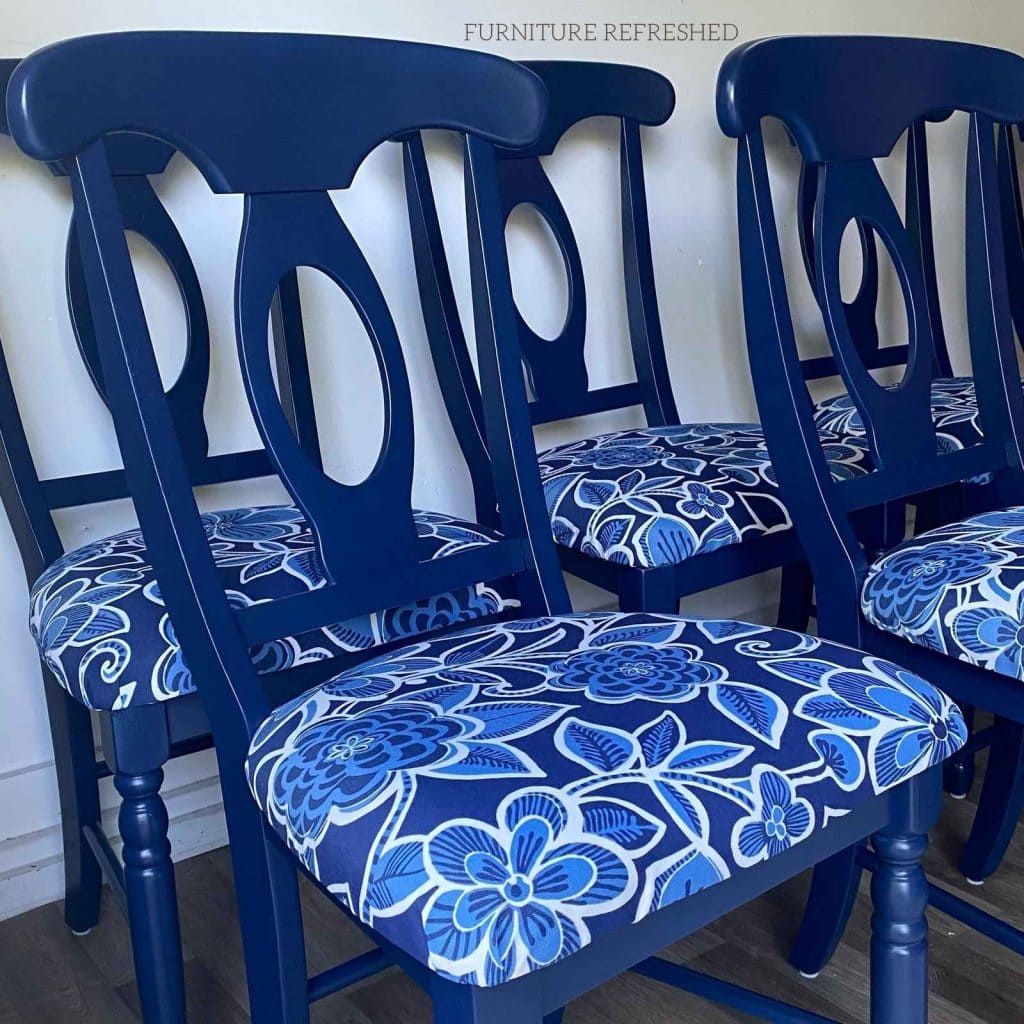 Photo of blue dining chairs with blue floral fabric upholstery on the seat cushions.