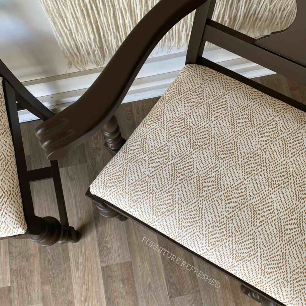 Close up photo of brown dining room seat cushions with white and brown upholstery on seats.