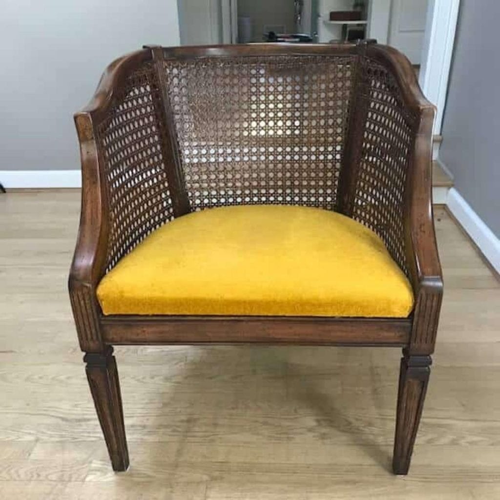 Before photo of brown caned club chair with a velvet mustard colored seat. 