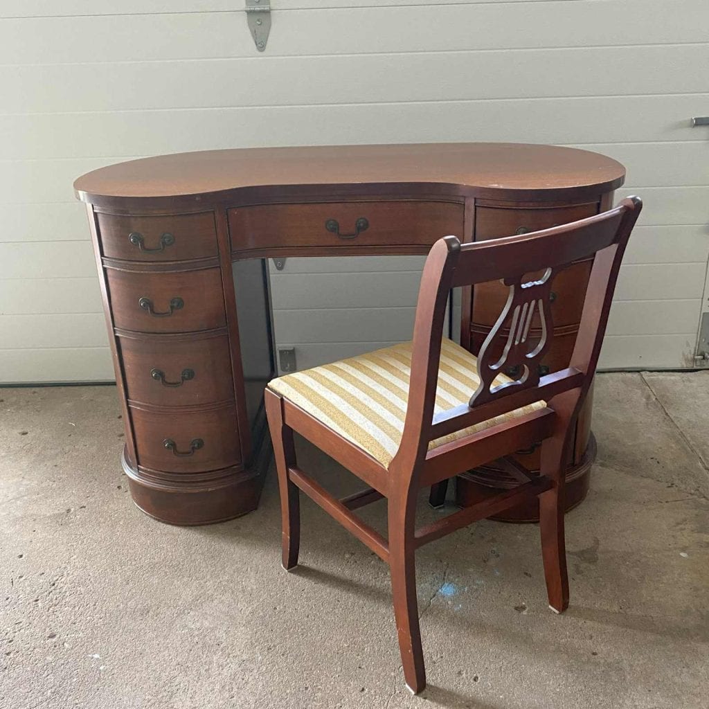 Before photo of kidney shaped desk with a coordinating chair.