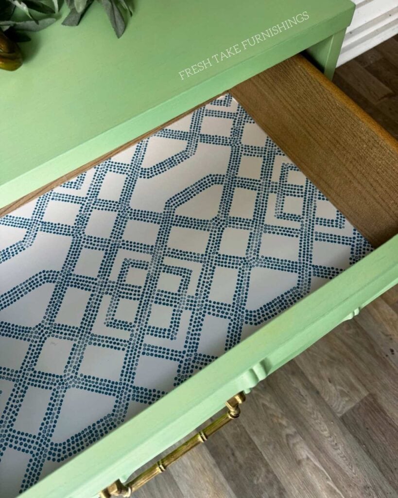 Clsoe up of drawer liner with blue geometric pattern in the green faux bamboo dresser.