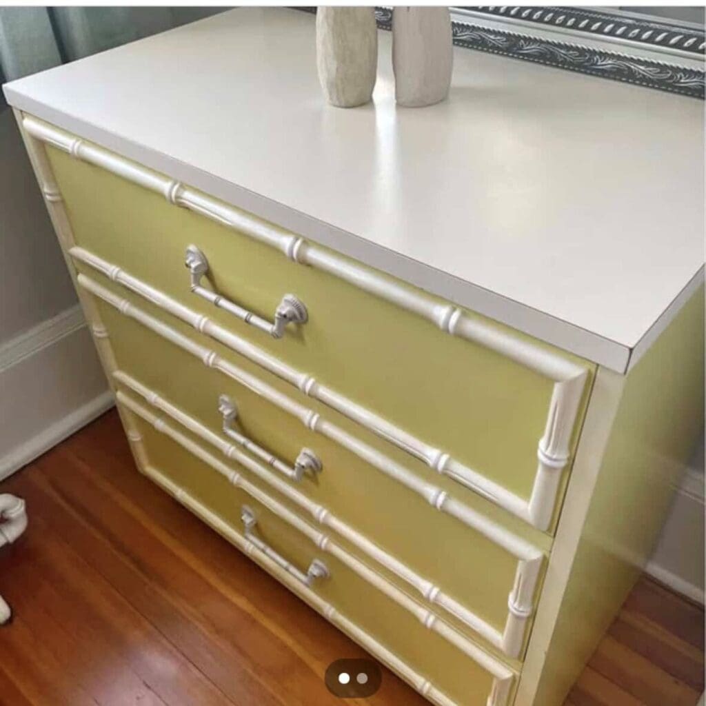Before photo of faux bamboo dresser with yellow and white paint on body and a white laminate top.