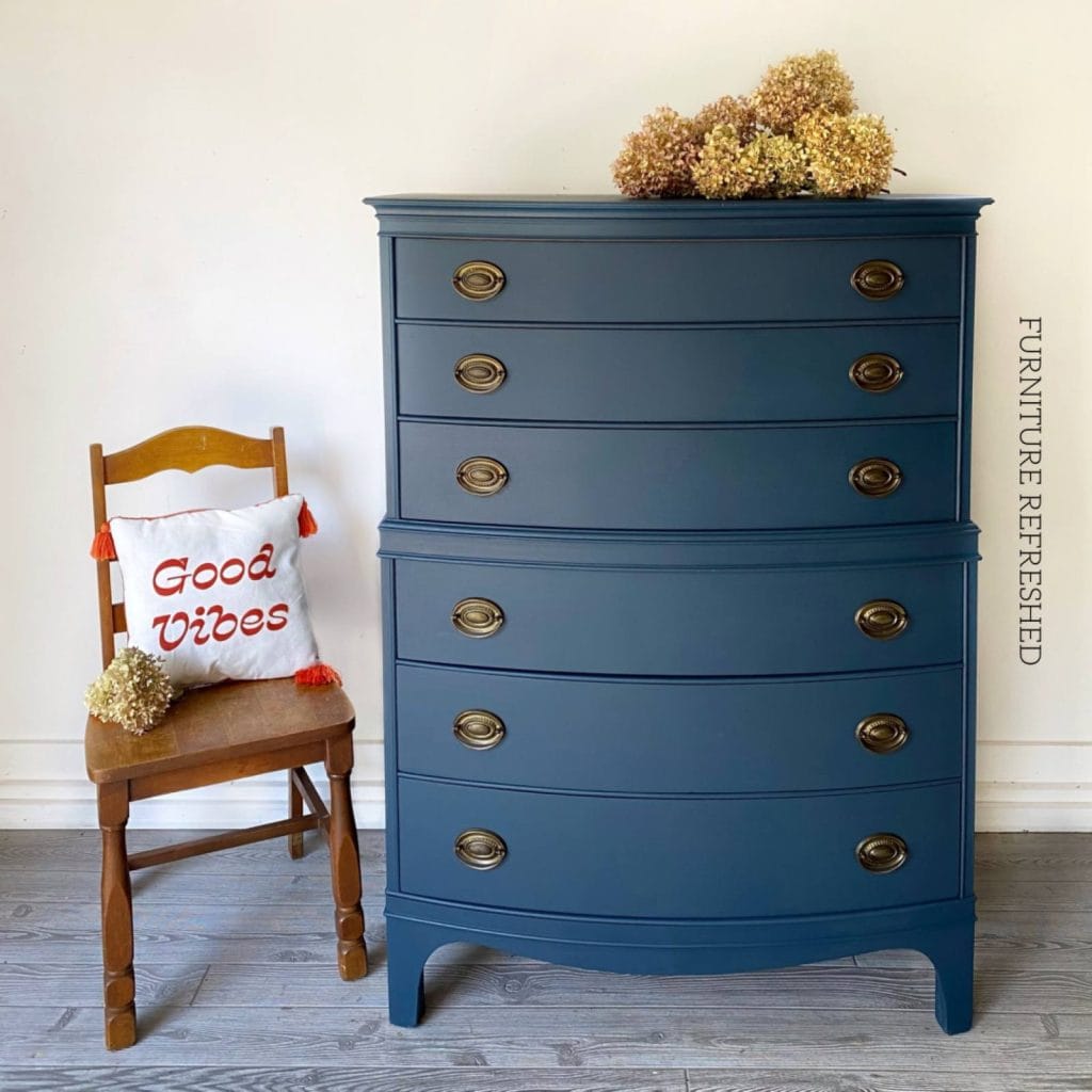 After photo of tallboy Hepplewhite dresser painted in a dark blue.