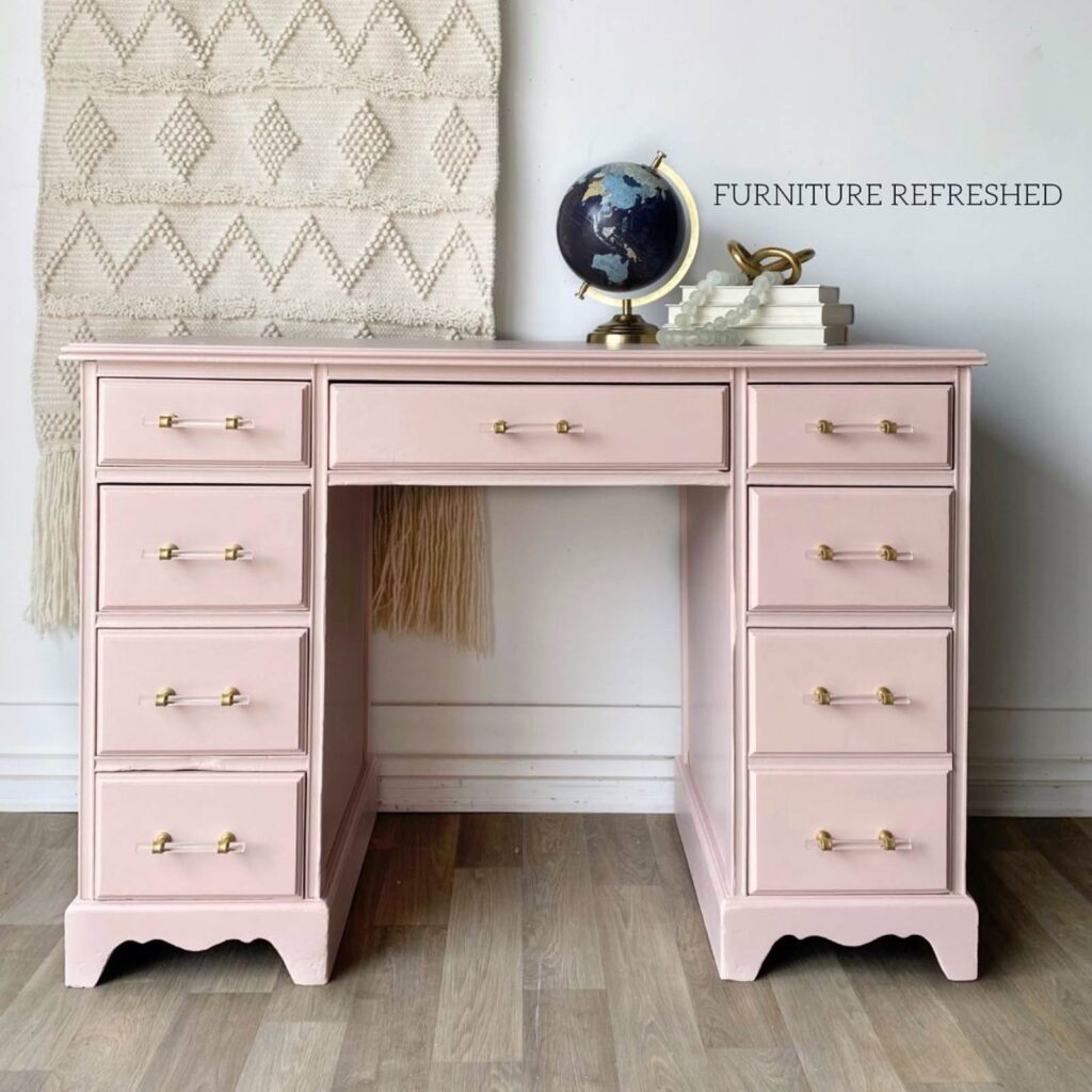 After photo of wooden desk painted pink with lucite hardware.