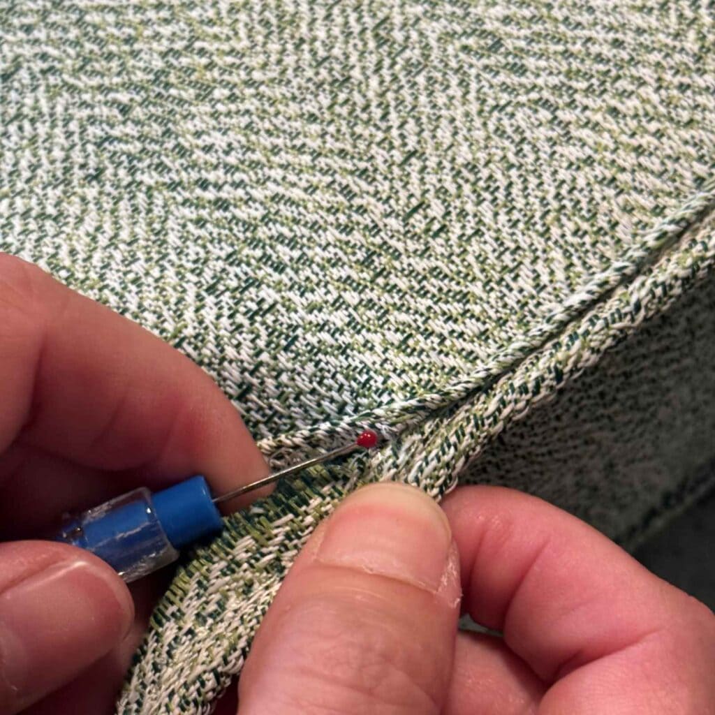 Using a seam ripper to open up the cushion and remove the old filling