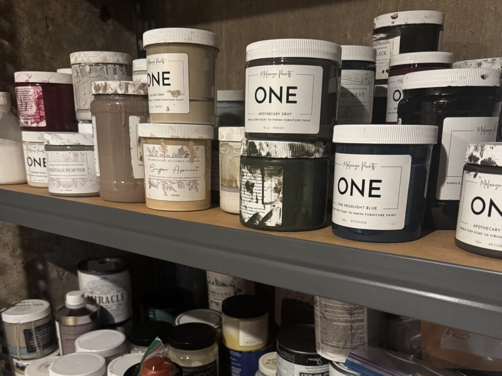 shelf of partially used furniture paint jars.