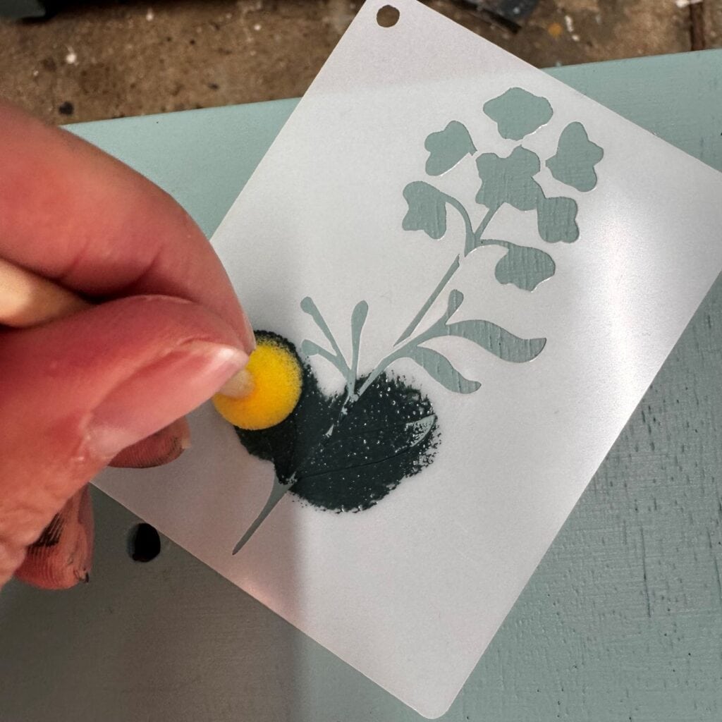 Gently blotting paint over stencil design.