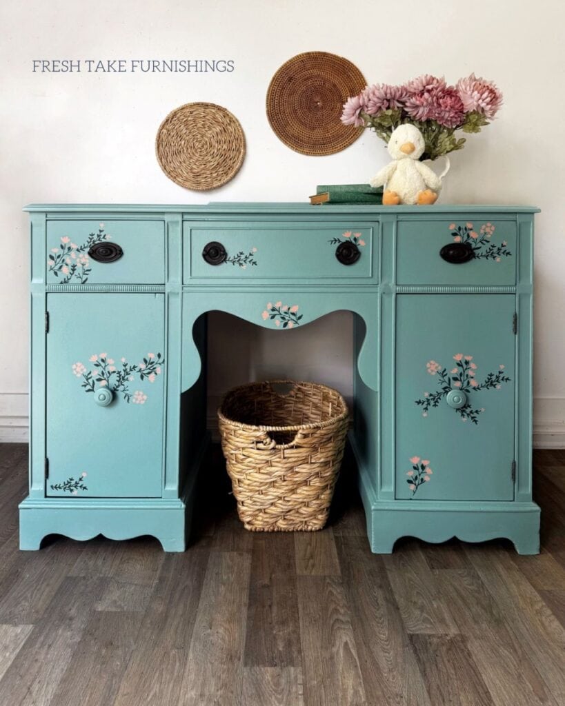 After photo of painted green vanity with floral stenciled accents.