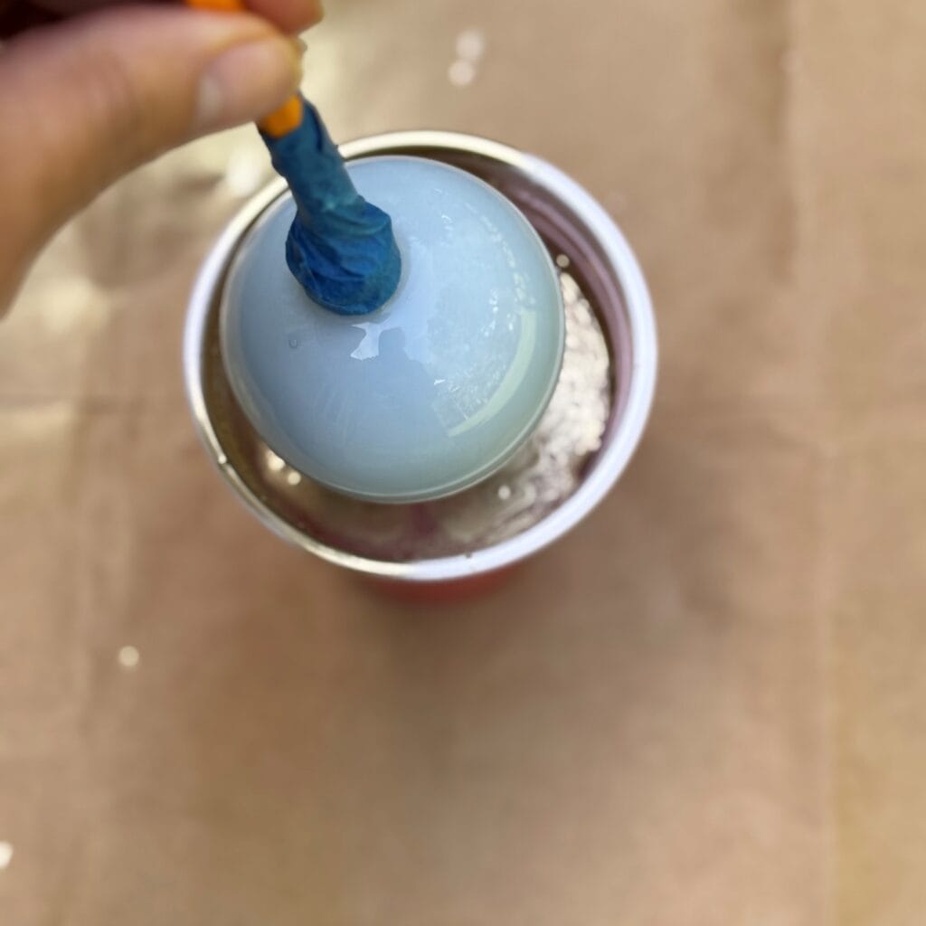 Dipping ornament into water/spray paint mixture.