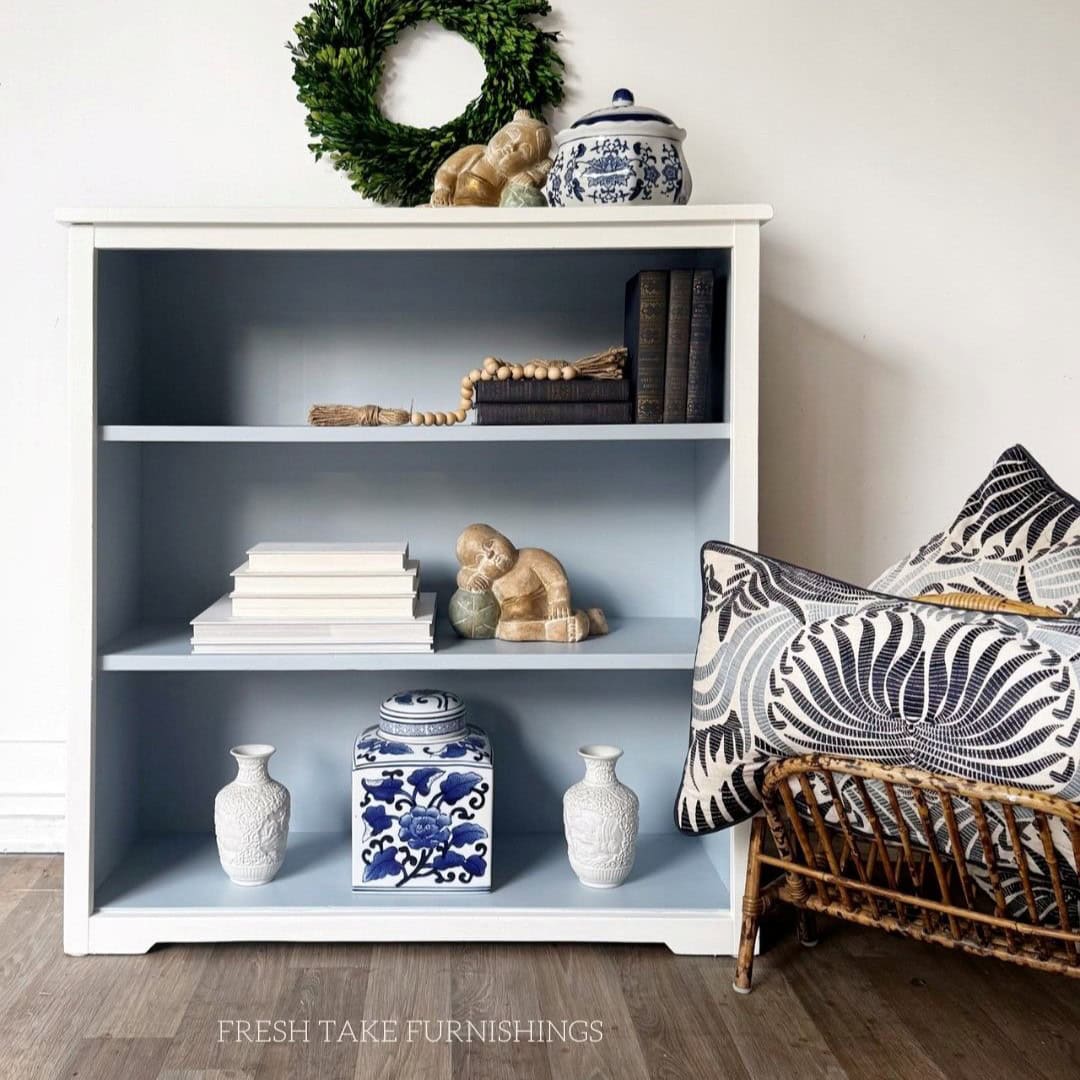 After photo of painted bookcase, white on the outside and light blue on the inside.