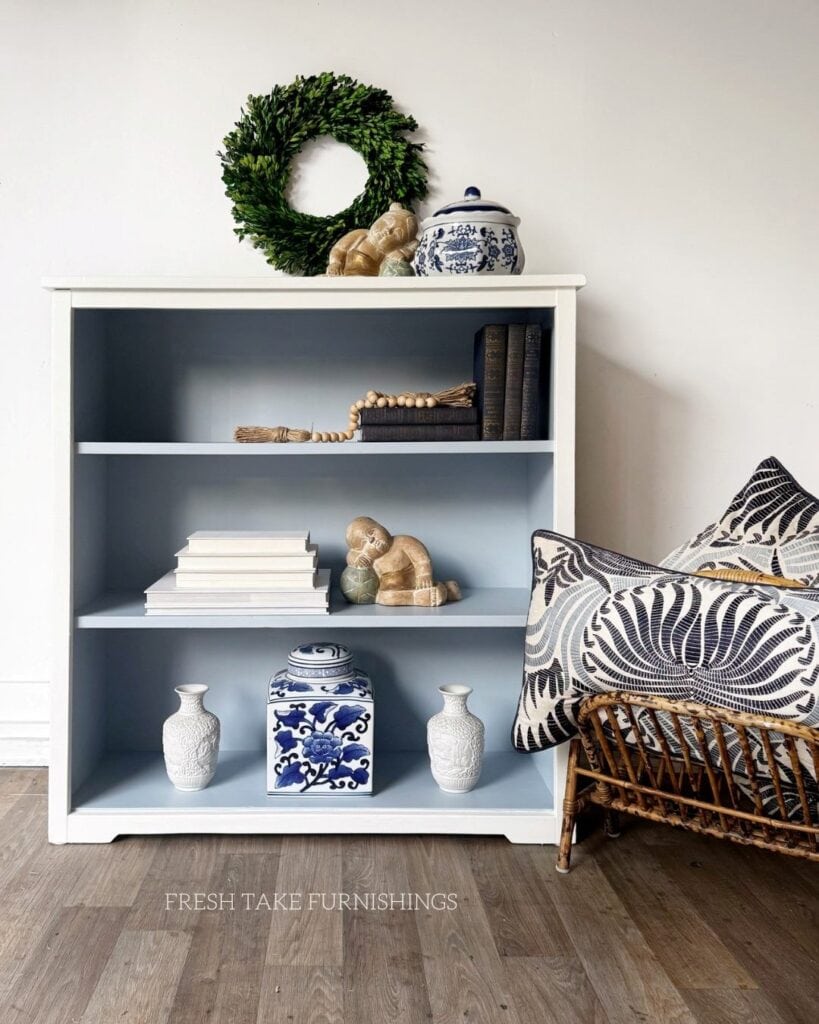 After photo of painted bookcase, white on the outside and light blue on the inside.