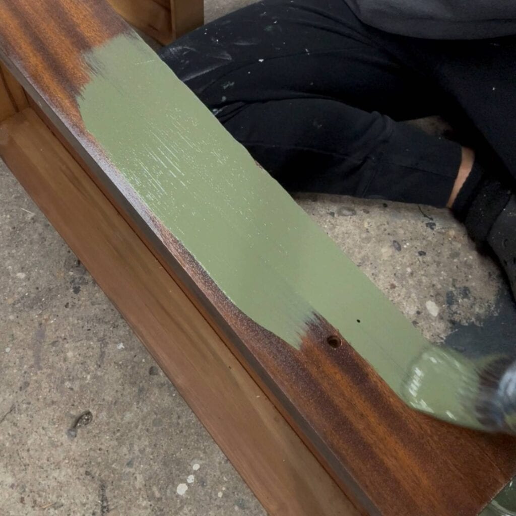 Applying paint to the desk drawer.