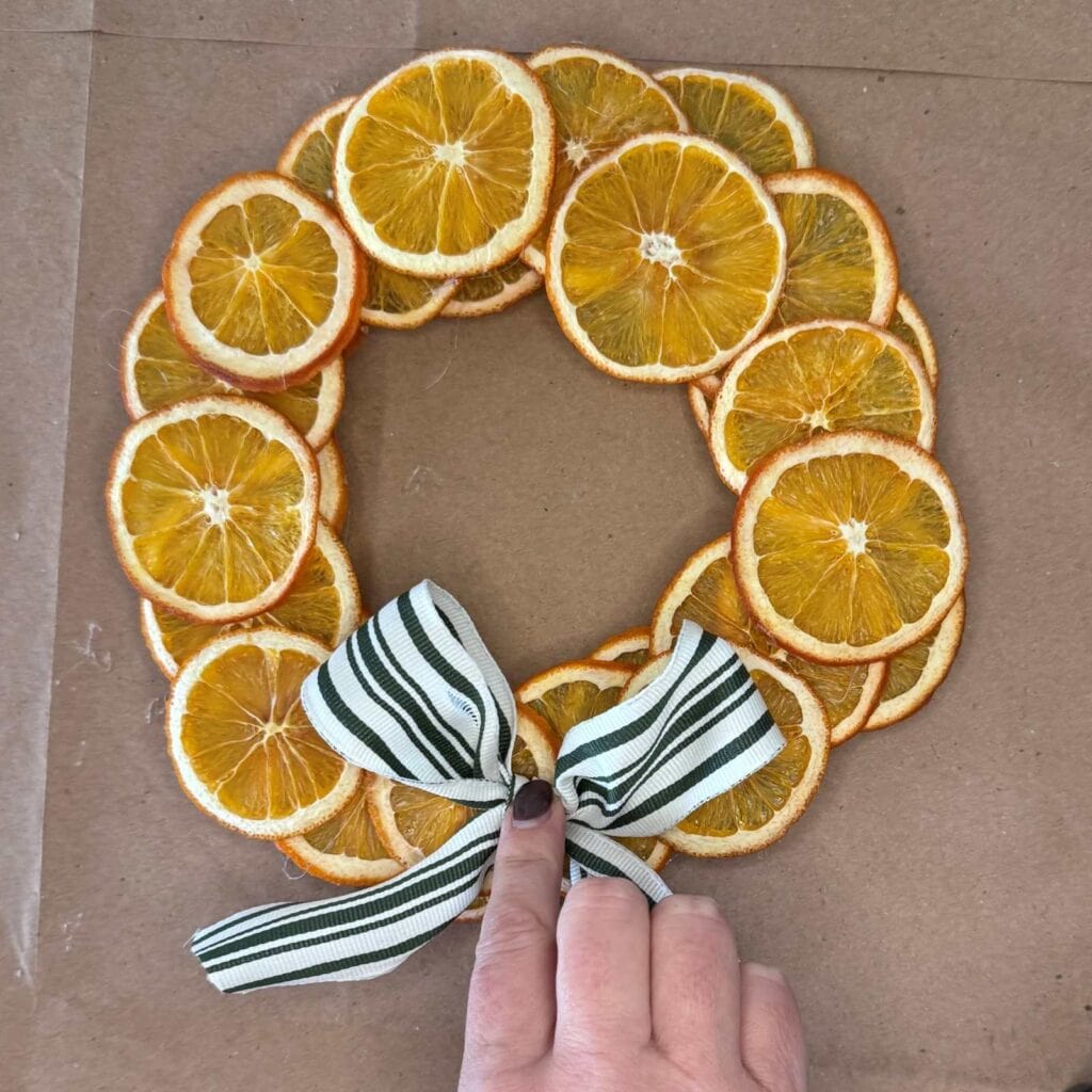 Adding bow to the front of the wreath