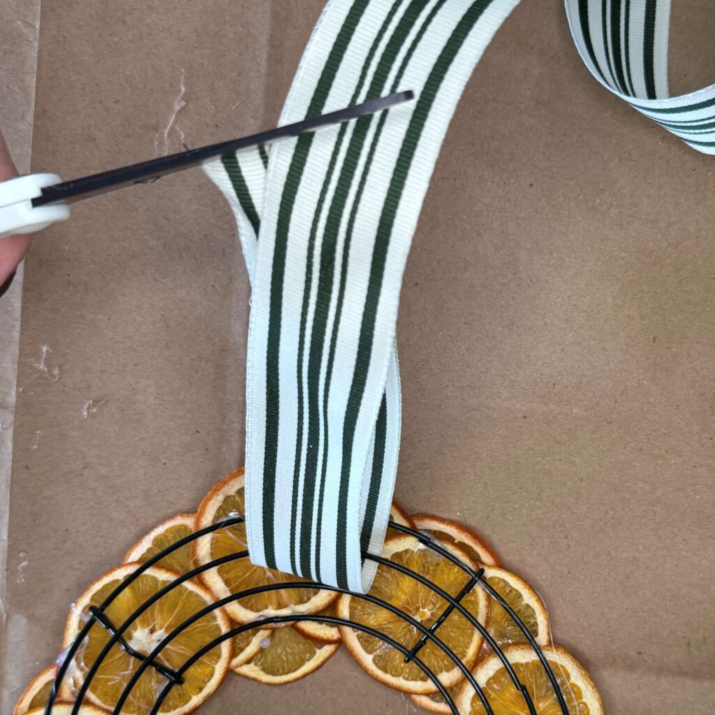 Adding ribbon to the back of the wreath.