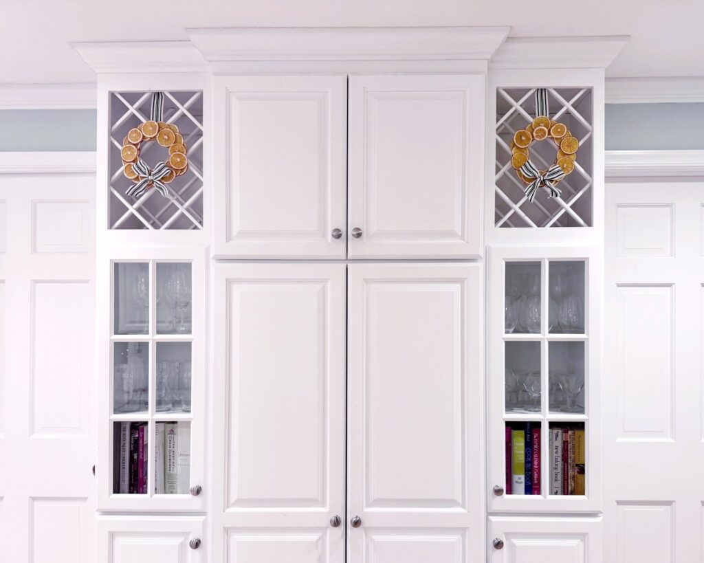 Photo of two wreaths hanging in cabinetry wine racks