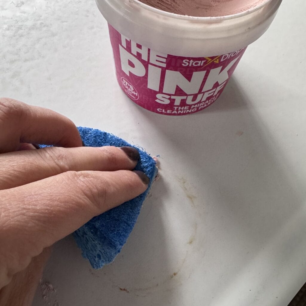 Using The Pink Stuff to clean the staining from the enameled metal top.